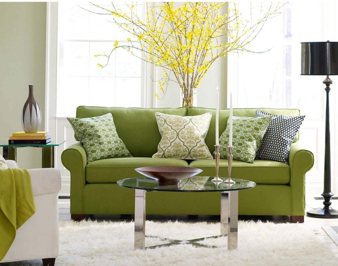 Green sofa in living room with yellow plant behind